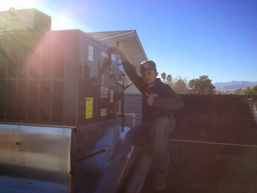 HVAC technician performing Heat Pump Repair on a rooftop unit in Jamestown